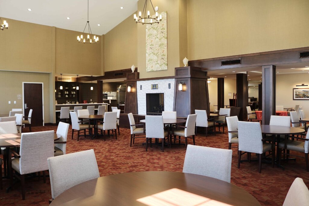 the dining room of Traditions North Bend in Cincinnati Ohio features several round tables with chairs around them
