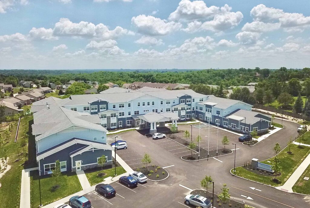 aerial view of Traditions at North Bend senior living building, parking lot and surrounding green area