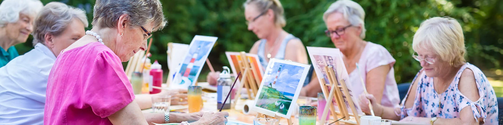 Senior women sitting outdoors at an event for painting