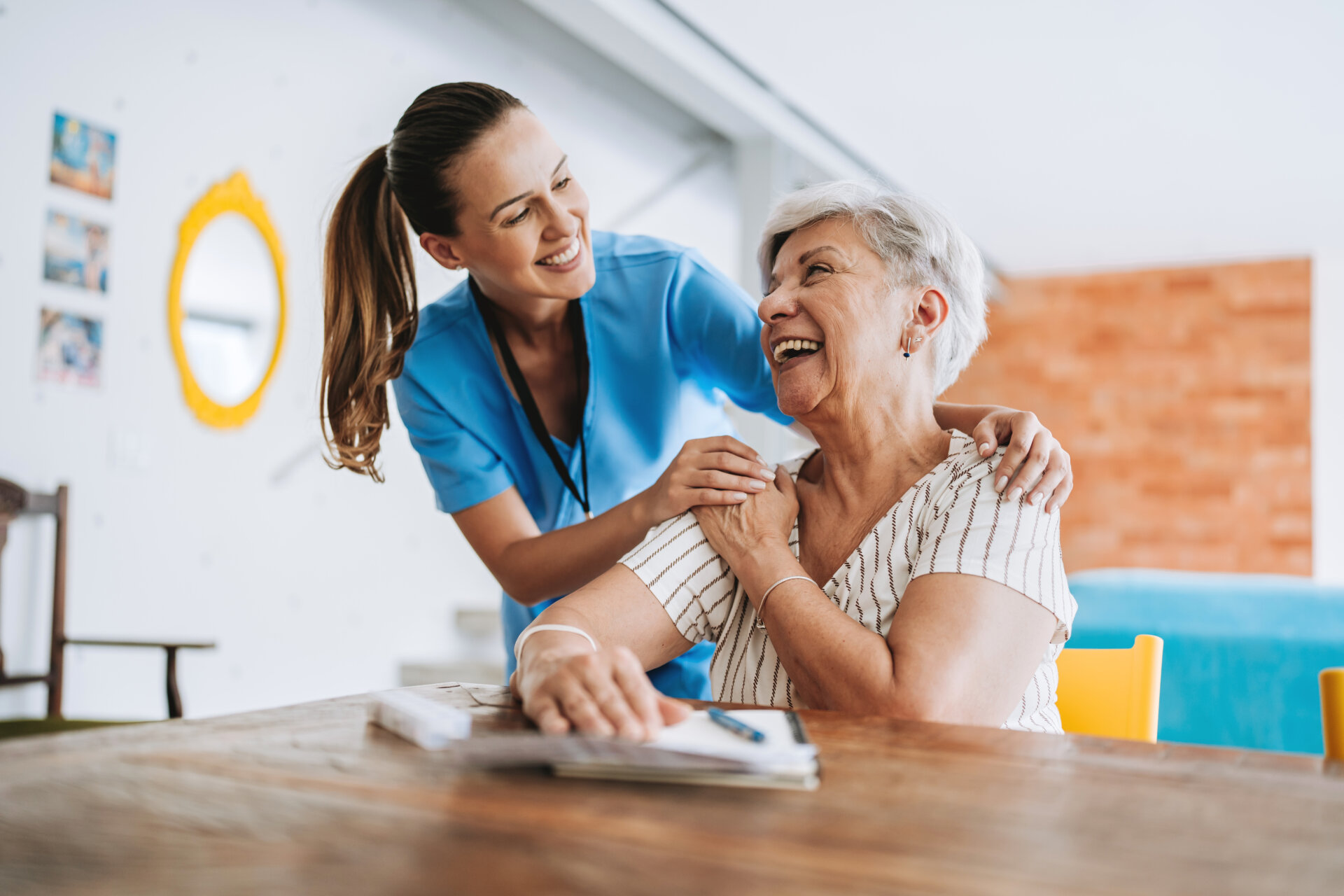 Home care healthcare professional hugging senior patient
